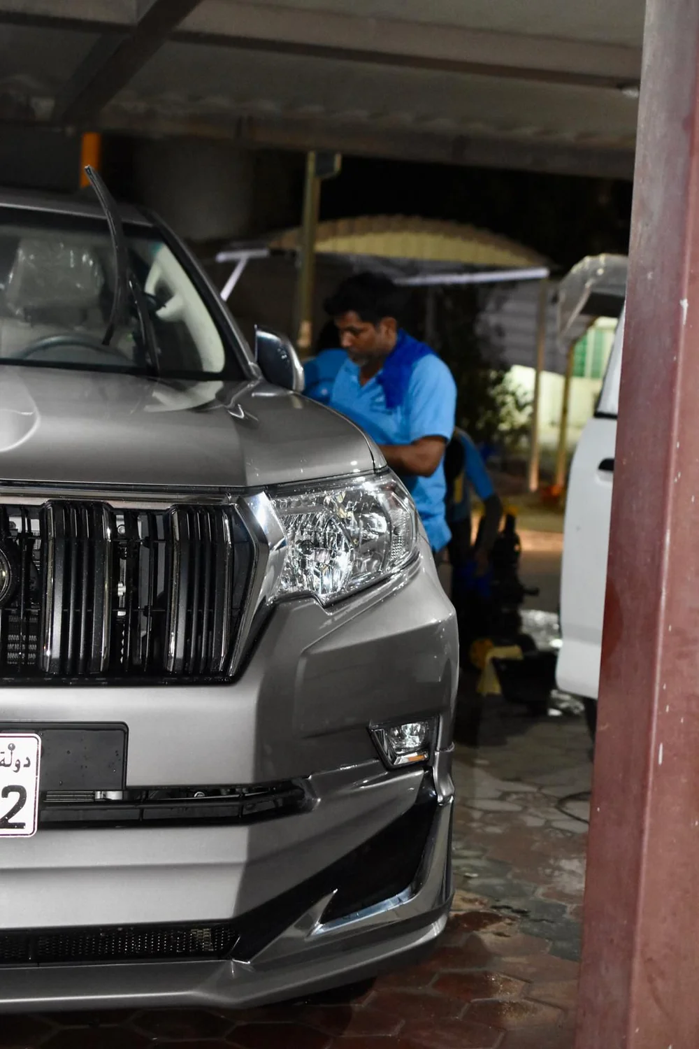 Mobile car wash technician cleaning vehicle exterior on-site in Kuwait - Posefore